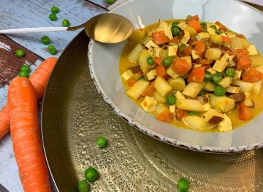 Leipziger Allerlei Suppe: Leckere low carb Suppe mit Erbsen und Möhren in Curry-Cashewsahne auf Teller angerichtet.