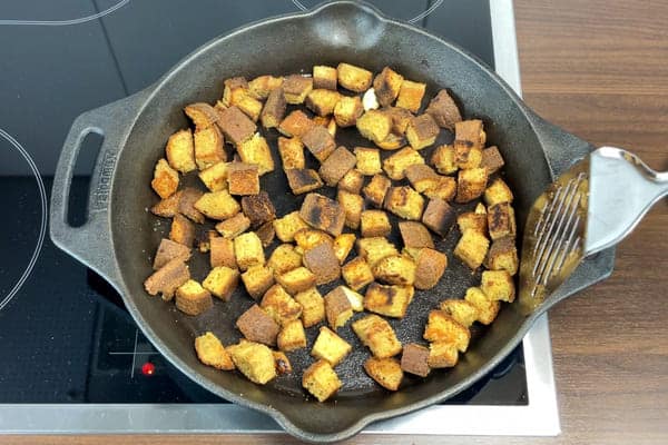 Für den Brotsalat wird altes low carb Brot mit Knoblauch und Olivenöl in einer Pfanne geröstet