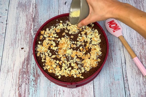 Low carb Eiskaffee Torte ohne Zucker in einer Springform wird mit gehackter zuckerfreier weißer Schokolade bestreut
