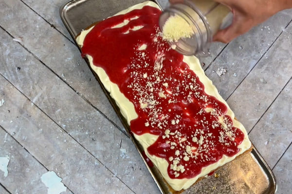 Low carb Erdbeer Tiramisu wird mit zuckerfreier weißer Schokolade bestreut.