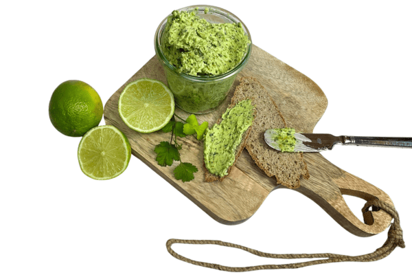Fertige Kräuterbutter mit Koriander und Limetten in einem Glas