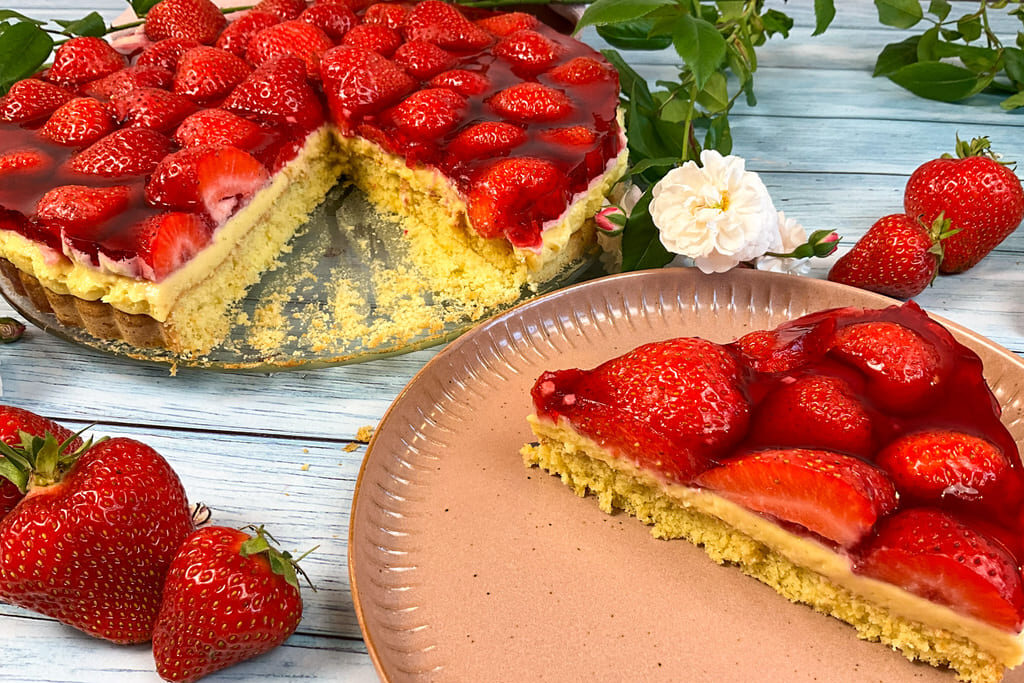 Angeschnittener low carb Erdbeerkuchen mit Pudding ohne Zucker auf Kuchentellern