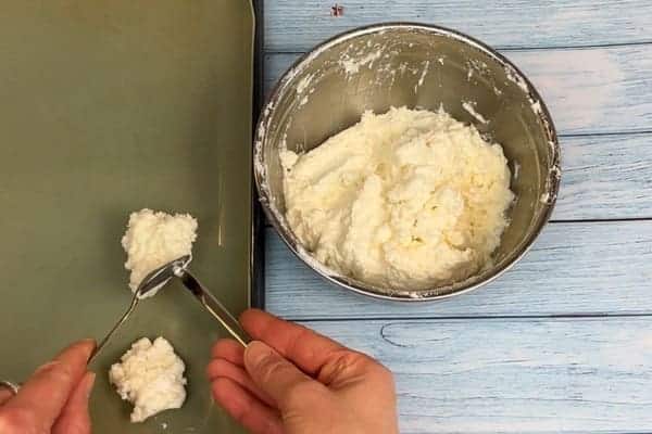 Die low carb Kokosmakronen werden mit zwei Teelöffeln geformt und auf ein Backblech gegeben