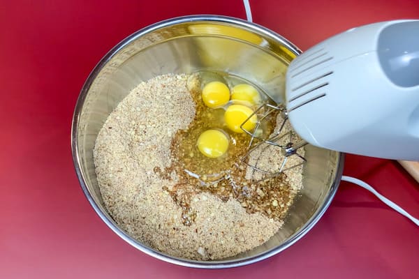 Lebkuchen Teig für das Tiramisu wird mit Eiern mit einem Handrührgerät vermixt