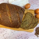 Low carb Leinsamenbrot mit knuspriger Kruste, dünn geschnitten, ballaststoffreich, ohne Mehl auf einem Holzbrett
