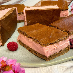 Selbst gemachte low carb Milchschnitte mit Himbeer Füllung auf einem Teller