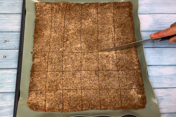Der low carb Pizza Cracker Teig wird vor dem Backen geschnitten.