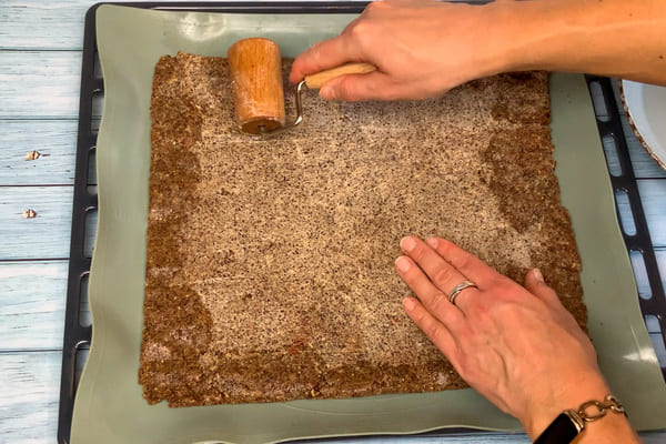 Low carb Pizza Cracker Teig wird auf einem Backblech ausgerollt