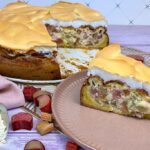 Angeschnittener low carb Rhabarberkuchen mit Baiserhaube auf Tellern