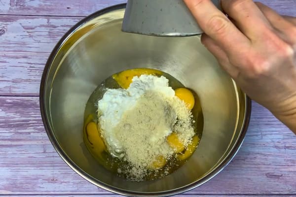 Eier, körniger Fischkäse und gemahlene Mandeln in einer Rührschüssel für den Teig der low carb Schüttelpizza
