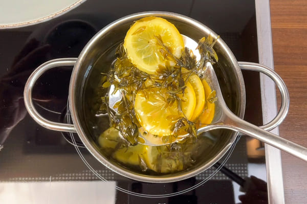 Zitrone und Waldmeister werden mit einem Schöpflöffel aus dem Waldmeister Sirup ohne Zucker entfernt