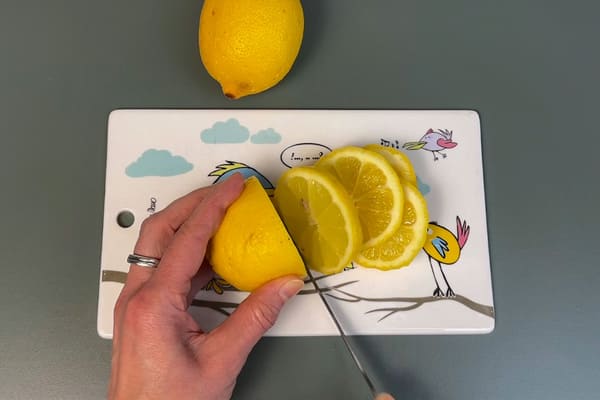 Bio Zitrone auf einem Brett, die in Scheiben geschnitten wird
